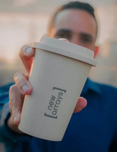 Daniel Sodré, fundador da New Arrays, estendendo um copo com a marca new arrays